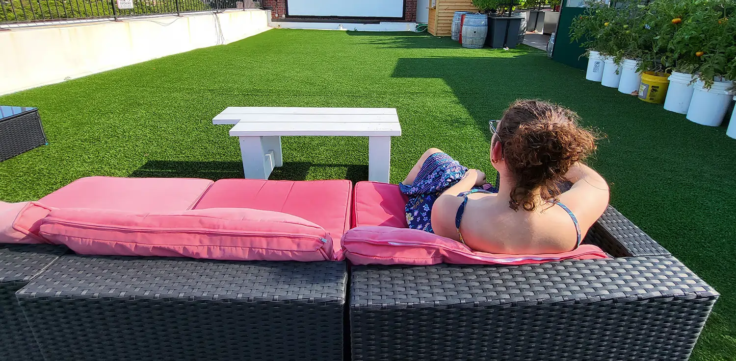woman relaxing on artificial grass rooftop